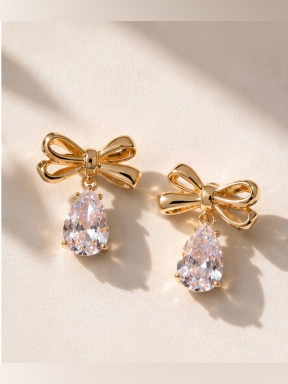 Elegant Gold Bow Earrings with Pale Pink Teardrop Crystals